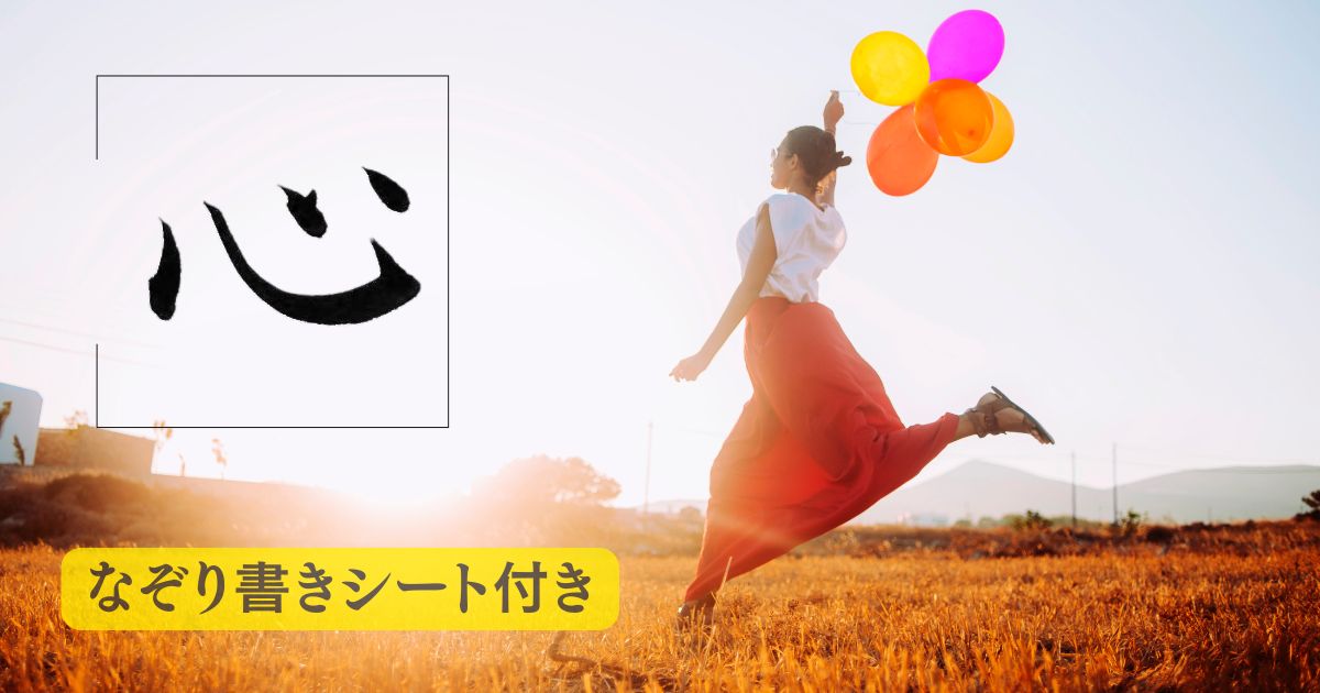 筆文字「心」。背景には草原で子供のように風船を持ってはしゃぐ女性。
