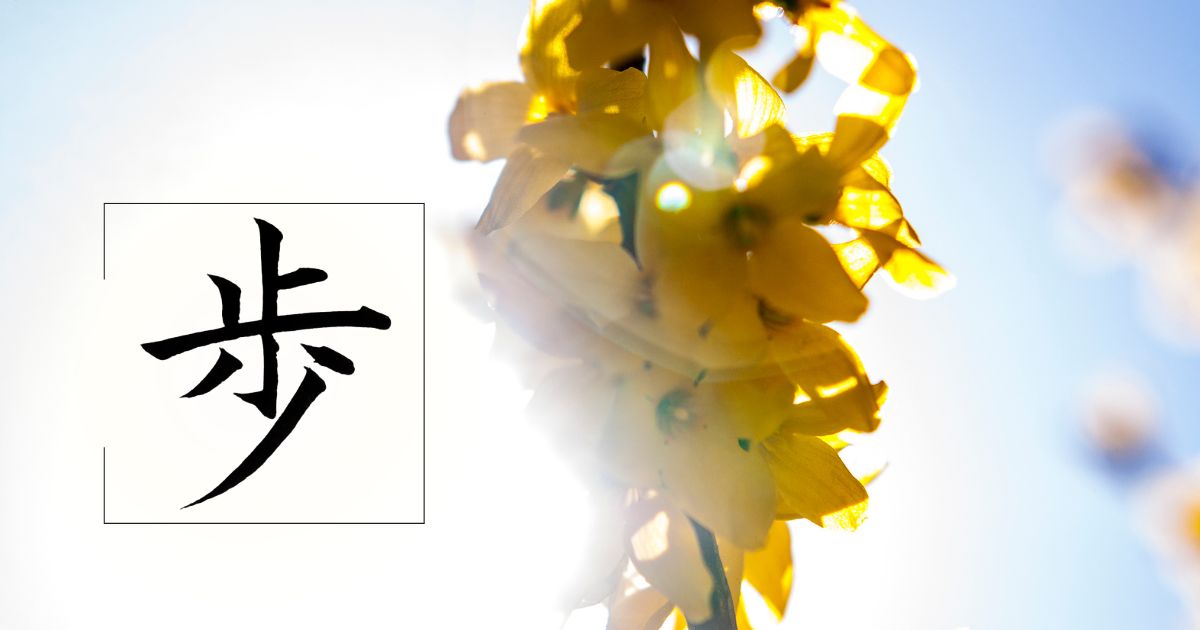 レンギョウの花のアップを背景に、漢字「歩」の筆文字