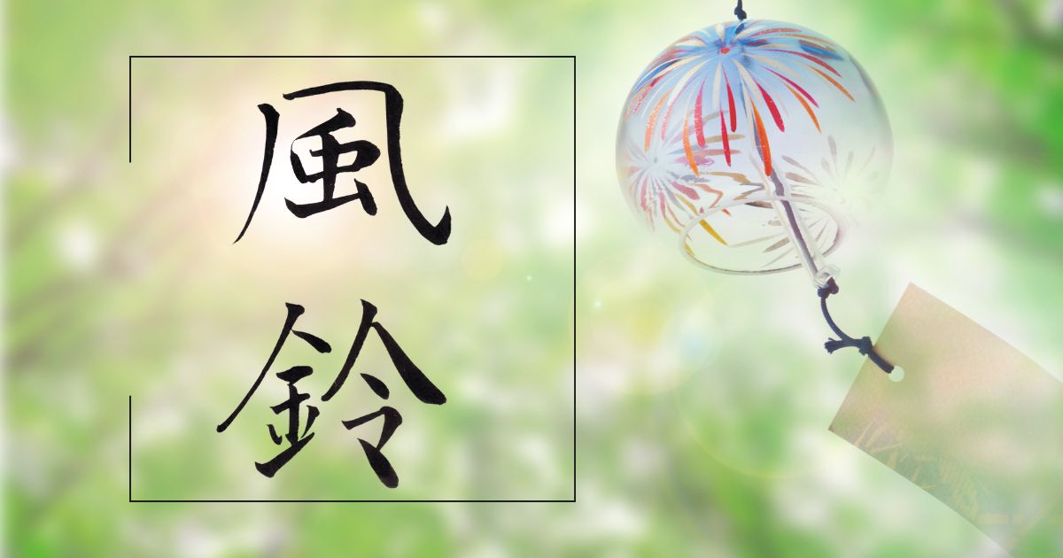 風鈴の筆文字と緑の木々を背景に揺れる風鈴。