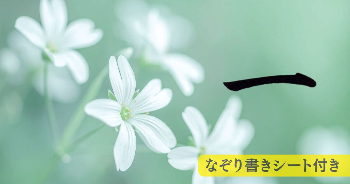 筆文字「一」。背景には緑の自然の中に、白い可憐な花が咲いている。