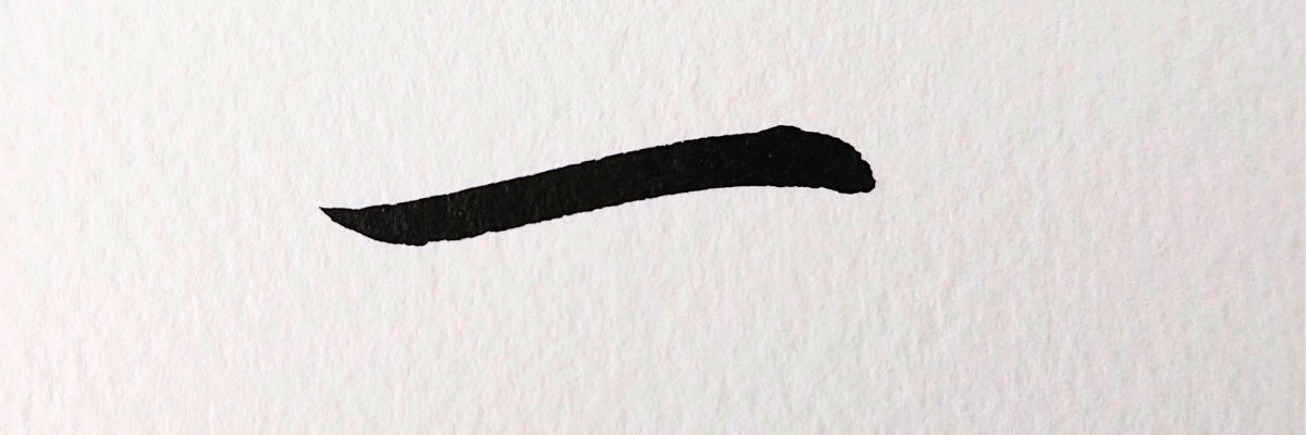 アップで「一」と筆文字で書かれている。ざらっとした厚手の紙。