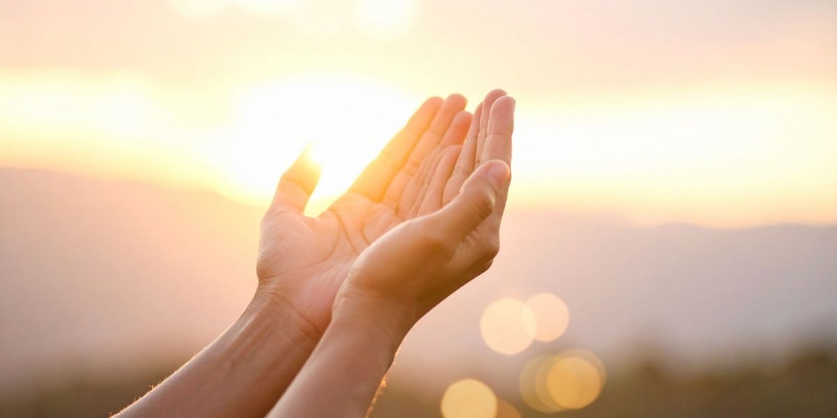 朝焼けを背景に、まじまじと自分の手を見つめる様子。