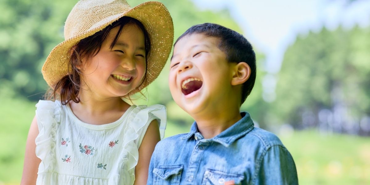 二人の幼い子供が笑顔いっぱいで楽しそうにしている。