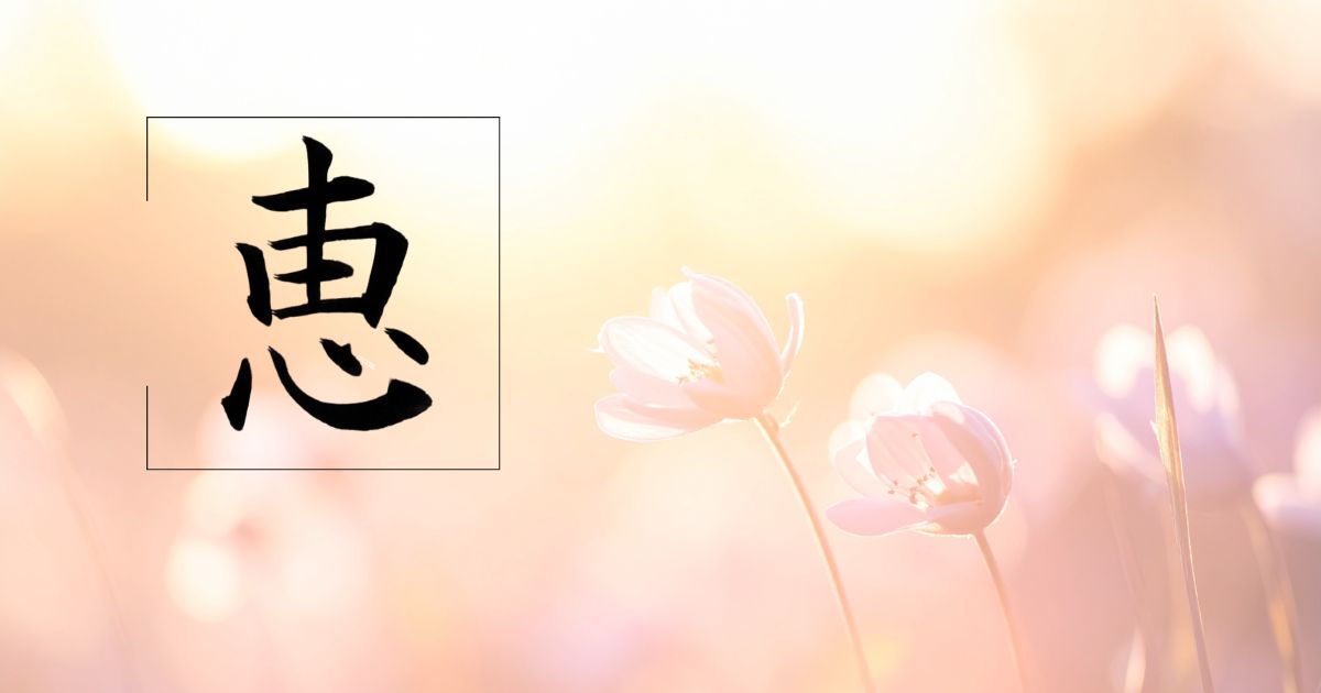 筆文字「恵」。背景には新緑がまぶしく輝いている様子。