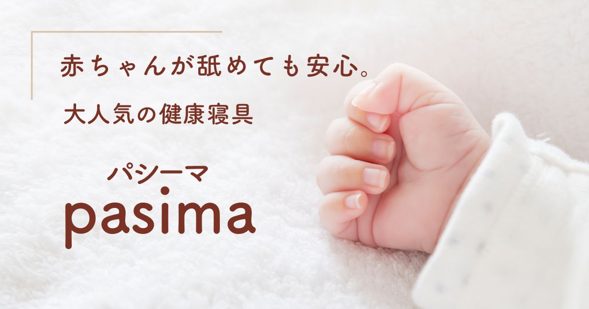 赤ちゃんが舐めても安心。大人気の健康寝具。「パシーマ」の文字。背景には赤ちゃんの小さな手。