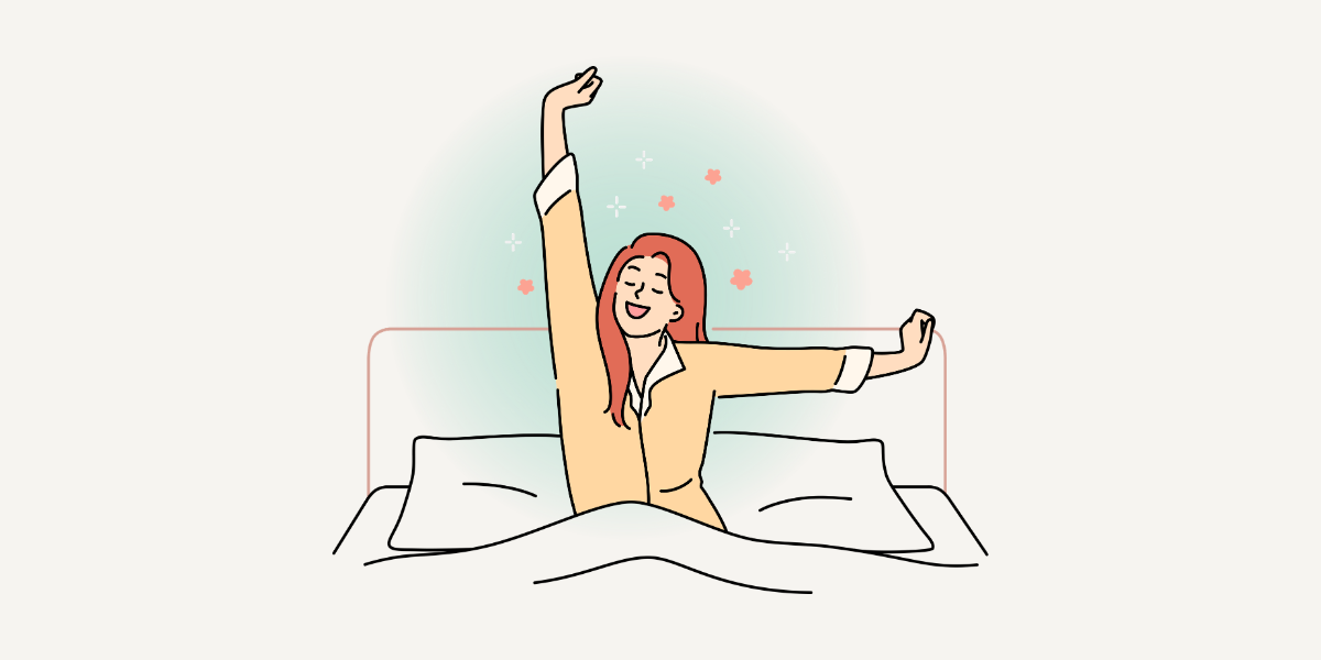 朝、気持ちよく起きた女性が布団の中で背伸びをしている様子。