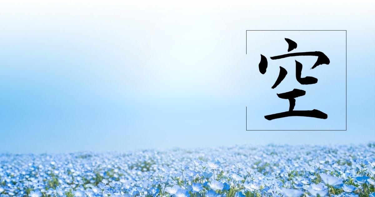 真っ青な空と一面のネモフィラを背景に、漢字「空」の筆文字