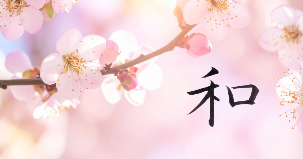 美しい薄ピンク色の桜の花を背景に、筆文字「和」